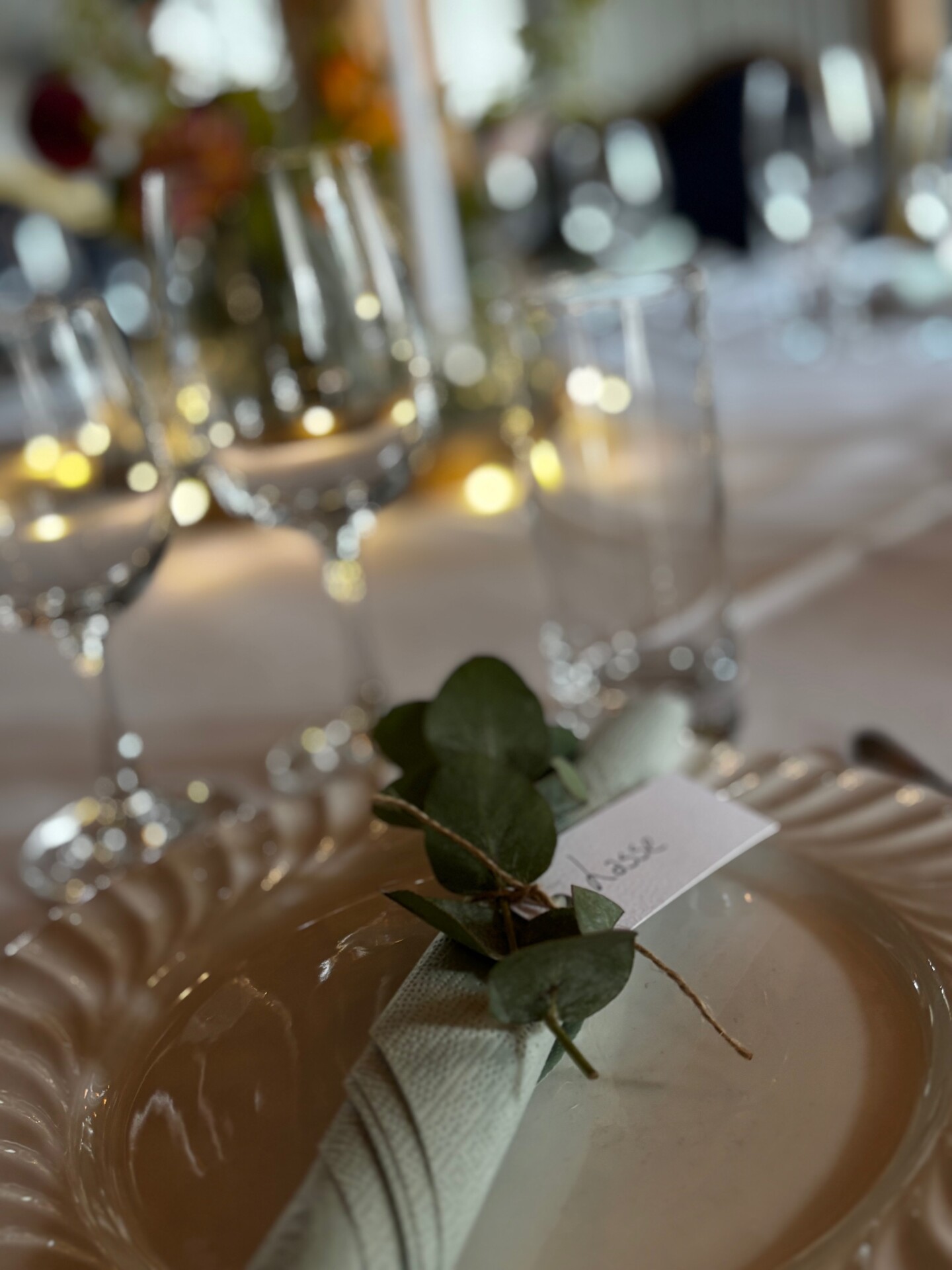 Borddækning med glas og grønne grene på Aamølle
